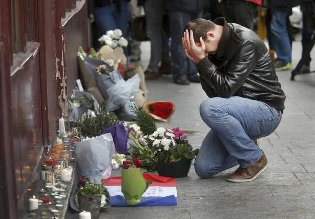 Người dân đặt hoa tưởng niệm các nạn nhân bên ngoài nhà hàng Le Carillon. Ảnh: Reuters