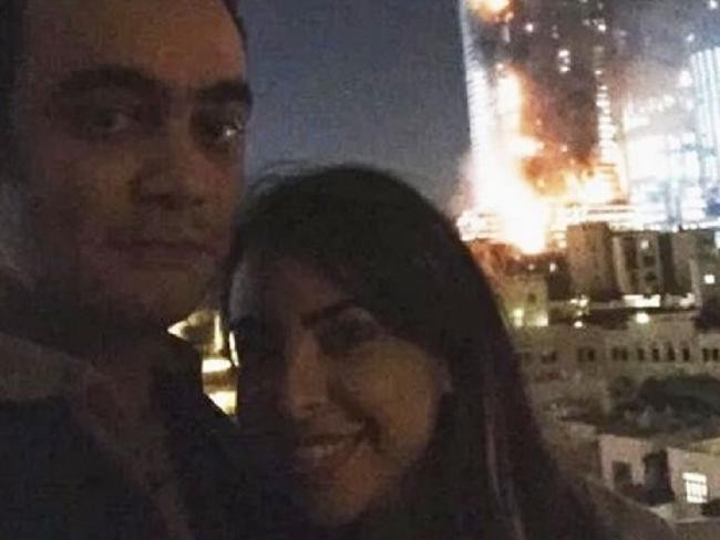 Cặp đôi chụp ảnh trước khách sạn cháy. Ảnh: News