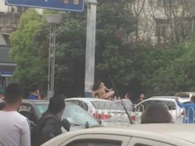 Giao thông bị ùn tắc vì cô gái khỏa thân, nhảy múa trên nóc ô tô. Ảnh: Shanghaiist