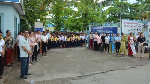 Học sinh và giáo viên trường tiểu học Hoàng Văn Thụ đứng tiễn thầy Khoa hiệu trưởng (ảnh báo PLVN)