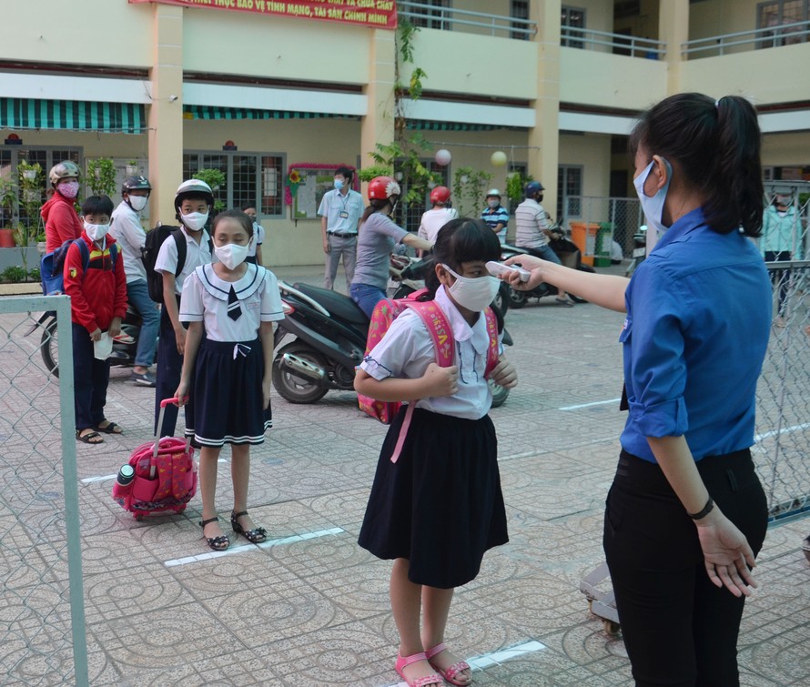 Giáo viên trường Tiểu học An Lạc 1, quận Bình Tân, TPHCM đo thân nhiệt học sinh trước khi vào trường