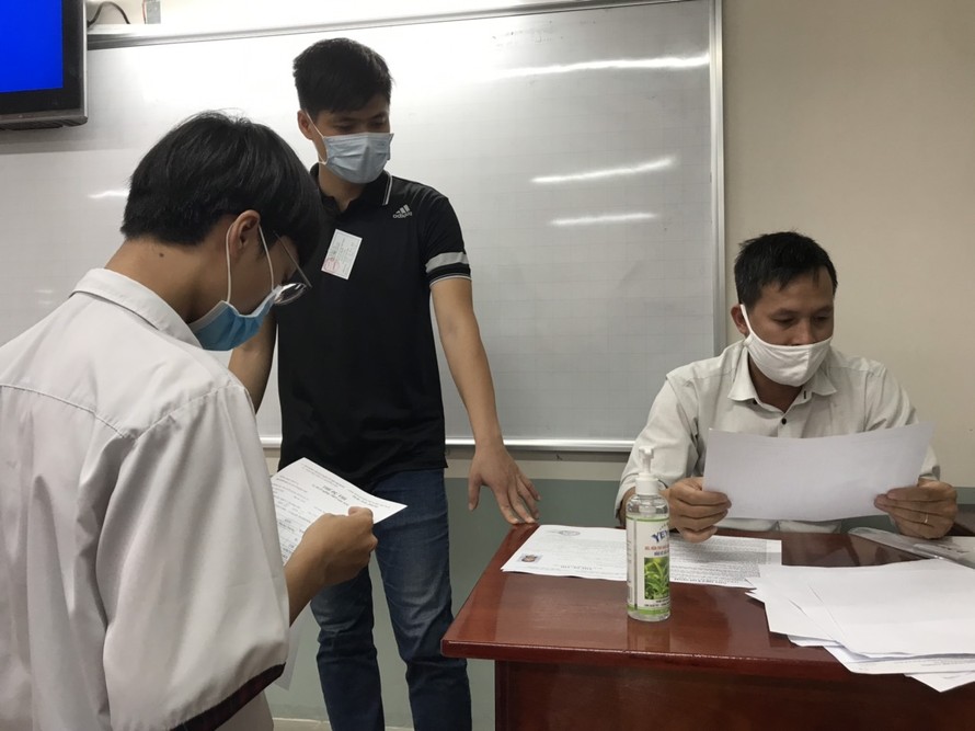 Giám thị coi thi và thí sinh kiểm tra thông tin dự thi tại điểm thi trường THPT Lê Qúy Đôn, quận 3