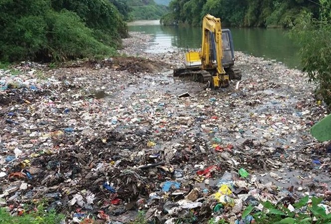 Hình ảnh máy xúc gạt rác thải xuống suối ở Hà Giang.