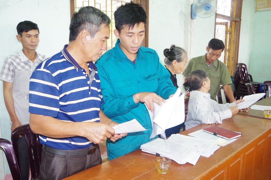 Cán bộ Ban CHQS xã Đồng Văn, huyện Thanh Chương, Nghệ An hướng dẫn người dân làm hồ sơ tham gia dân công hỏa tuyến theo Quyết định 49