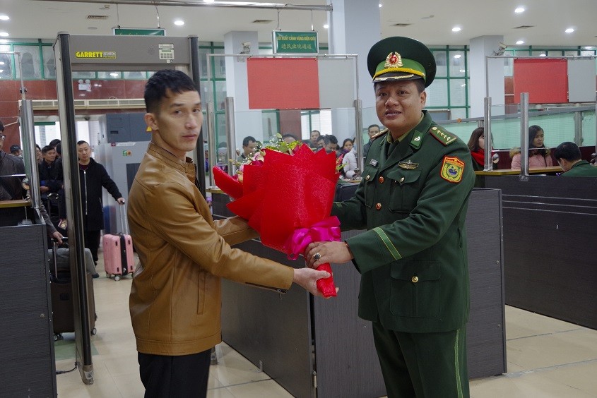 Du khách đầu tiên xuất cảnh qua Cửa khẩu quốc tế Lào Cai được cán bộ biên phòng tặng hoa chúc mừng, sáng 1/1/2019