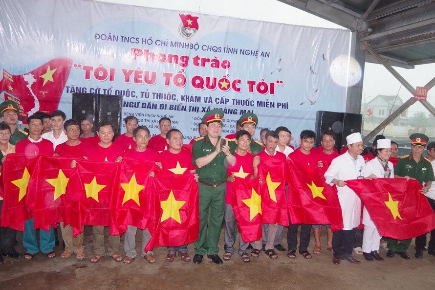 Thượng tá Thái Đức Hạnh, Chính ủy Bộ CHQS tỉnh Nghệ An và các đơn vị phối hợp tặng 2.500 lá cờ Tổ quốc cho ngư dân thị xã Hoàng Mai