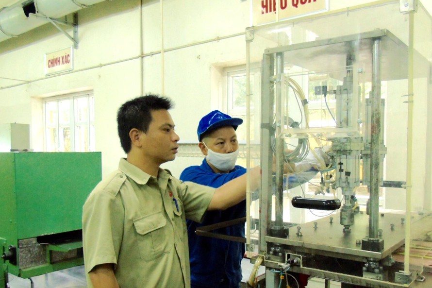 Kỹ sư Nguyễn Tiến Hưng (trái) kiểm tra thiết bị sản xuất sản phẩm quốc phòng tại Nhà máy Z121