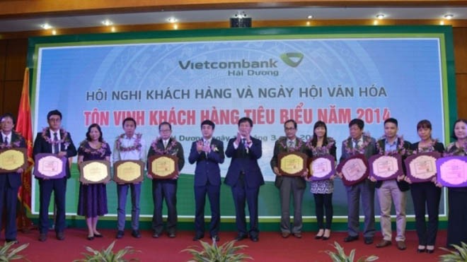  Chủ tịch HĐQT Nghiêm Xuân Thành (thứ 6 từ trái sang) và ông Phạm Anh Tuấn – Phó Trưởng ban Nội chính TW (thứ 7 từ phải sang) trao kỷ niệm chương tôn vinh các khách hàng tiêu biểu năm 2014 của Vietcombank Hải Dương