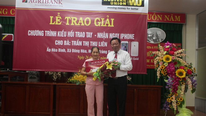 Khách hàng Trần Thị Thu Liên nhận giải thưởng do ông Nguyễn Huy Trinh giám đốc Agribank Đồng Nai trao tặng.