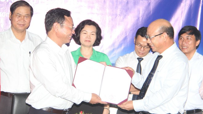Phó chủ tịch UBND tỉnh Lâm Đồng Nguyễn Văn Yên (trái) trao quyết định sử dụng đất xây dựng trạm thu mua nguyên liệu sữa cho đại diện Vinamilk.