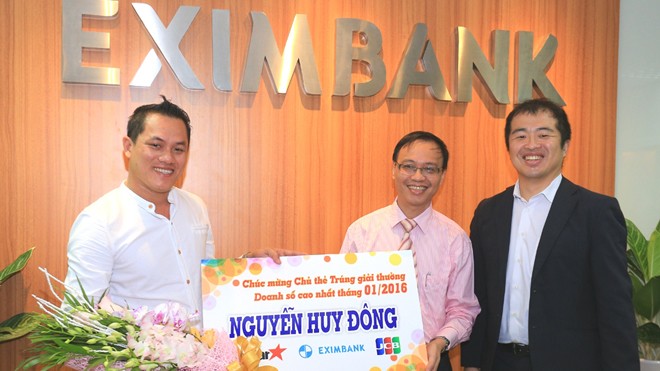 Đại diện Eximbank, ông Nguyễn Hồ Hoàng Vũ – Phó Tổng Giám đốc Eximbank (thứ 2 bên phải) đại diện trao quà và hoa lưu niệm cho khách hàng Nguyễn Huy Đông.