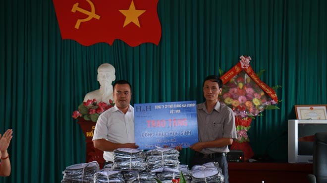 Ông Trần Xuân Đại – Phó TGĐ Công ty CP TT H&H Luxury VN và đại diện Phòng giáo dục và Đào tạo Huyện Tân Sơn, trao nhận đồng phục cho các em