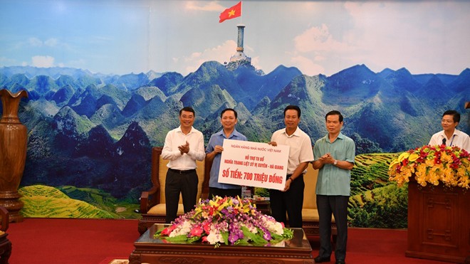 Thống đốc NHNN Lê Minh Hưng và Phó Thống đốc Đào Minh Tú (bên trái) trao tặng số tiền 700 triệu đồng hỗ trợ tu bổ Nghĩa trang liệt sỹ Quốc gia Vị Xuyên