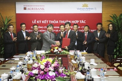 Phó Tổng Giám đốc Agribank Phạm Đức Tuấn, đại diện Agribank và Phó Tổng Giám đốc Vietnam Airlines Trịnh Ngọc Thành, đại diện Vietnam Airlines, ký kết Thỏa thuận hợp tác giữa hai đơn vị 