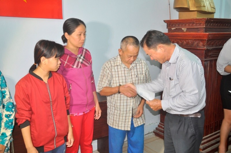 Ông Phạm Thanh Hùng, Phó Chủ tịch UBND xã Đa Phước trao tặng tiền hỗ trợ người dân.