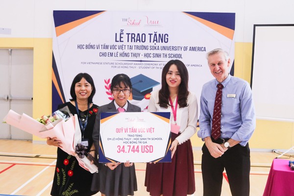 Bà Trần Thị Như Trang – Giám đốc Quỹ Vì Tầm Vóc Việt và ông Greg Hollis – Hiệu trưởng trường cấp III TH School (bên phải), trao tặng học bổng cho em Lê Hồng Thụy