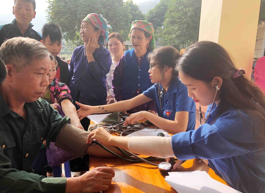 Những tình nguyện viên trường CĐ Y Dược Phú Thọ đo huyết áp cho bà con vùng lũ Yên Bái.