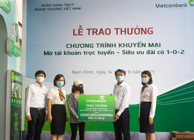 Lãnh đạo chi nhánh Vietcombank Nam Định trao thưởng 1 tỷ đồng cho cô gái 19 tuổi may mắn - Ảnh: Hoàng Long
