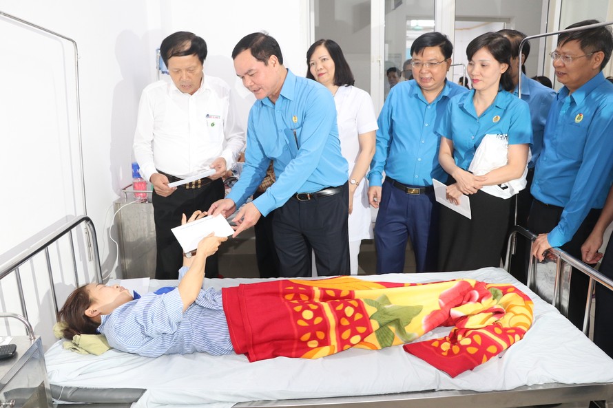 Ông Nguyễn Đình Khang, Chủ tịch Tổng Liên đoàn Lao động VN đến thăm, tặng quà công nhân bị ngộ độc, phải nhập viện - Ảnh: Hoàng Long