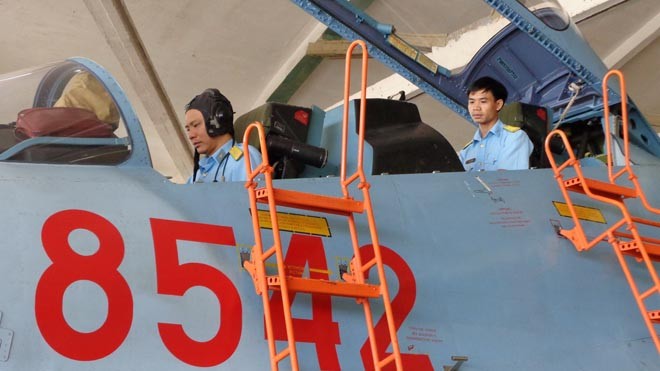Thiếu tá Nguyễn Công Tênh (ngồi trước) và trung úy Trần Gia Chuân kiểm tra thiết bị trên máy bay Su 30MK2. Ảnh: T.Đ