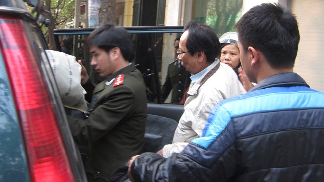 Ông Hồ Văn Hải (áo trắng) bị áp giải về cơ quan điều tra