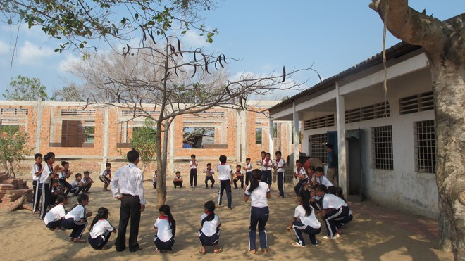 Các em học sinh Trường tiểu học Trần Quốc Toản vui chơi trên công trường đầy cát đá