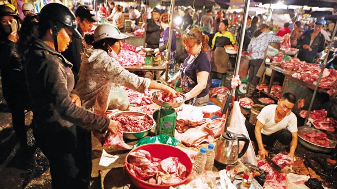 Cảnh mua bán thịt lợn nhếch nhác khó đảm bảo VSATTP tại chợ đầu mối phía Nam Hà Nội. Ảnh chụp lúc 4h30 sáng ngày 9/4/2014. Ảnh: Hồng Vĩnh