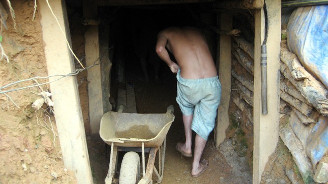 Một công nhân vào hầm khai thác vàng. Ảnh: Nam Cường