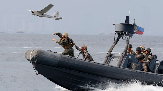 Lính hải quân Philippines và Mỹ phóng máy bay không người lái từ tàu tuần tra trong cuộc tập trận chung “Carat” ở thành phố Cavite, phía tây Manila, hồi tháng 6/2013. Ảnh: Erik De Castro