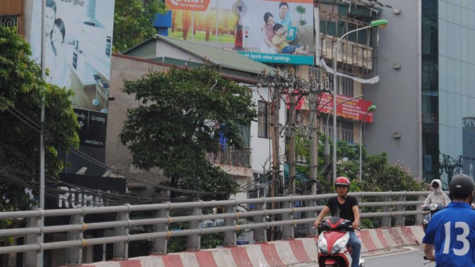 Hai tấm biển quảng cáo lậu trên mặt phố Đại Cồ Việt. ảnh: Minh Tuấn