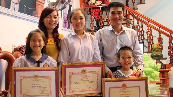 Gia đình anh Thành, chị Yến với những tấm giấy khen của Công an tỉnh Bắc Giang.