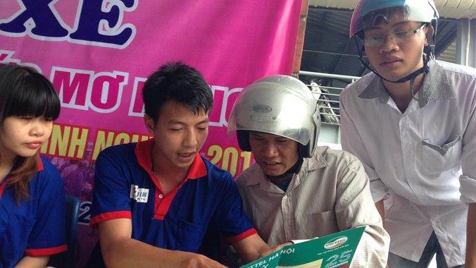 Thí sinh và người nhà được tình nguyện viên giúp đỡ tại bến xe ngày 30/6. Ảnh: Nguyễn Hà