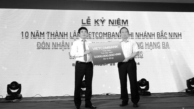 Ông Nghiêm Xuân Thành - Tổng giám đốc Vietcombank (bên trái) trao số tiền ủng hộ 3 tỷ đồng xây dựng trường học trên địa bàn tỉnh Bắc Ninh 