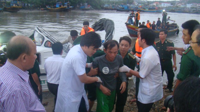 Lực lượng cứu hộ đưa các ngư dân lên bờ. Ảnh: Mạnh Thắng
