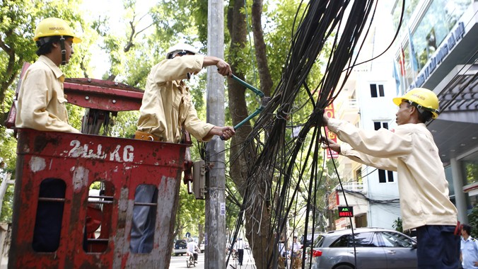 Công ty chiếu sáng và thiết bị đô thị Hà Nội dọn “rác trời” trên phố Quang Trung. ảnh: Như Ý