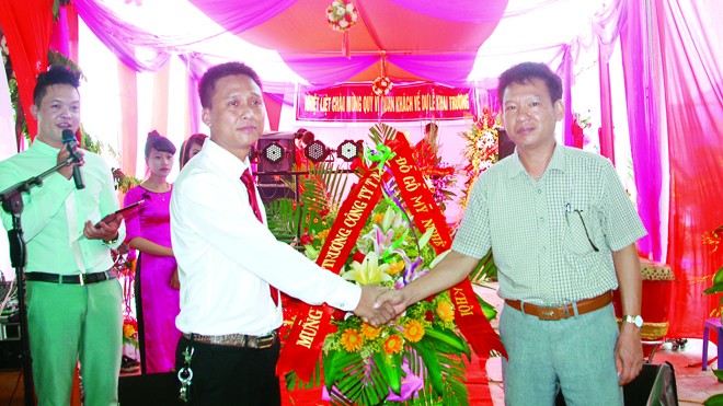 Ông Vũ Minh Khôi, Giám đốc Công ty TNHH đồ gỗ mỹ nghệ Minh Khôi (bên trái) đón nhận chúc mừng từ đối tác 