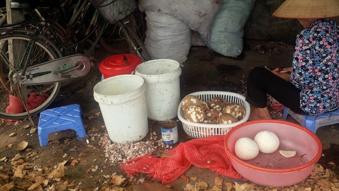 Người phụ nữ này chế biến nguyên liệu thô cho sản phẩm kem sữa dừa ngay bên lề đường