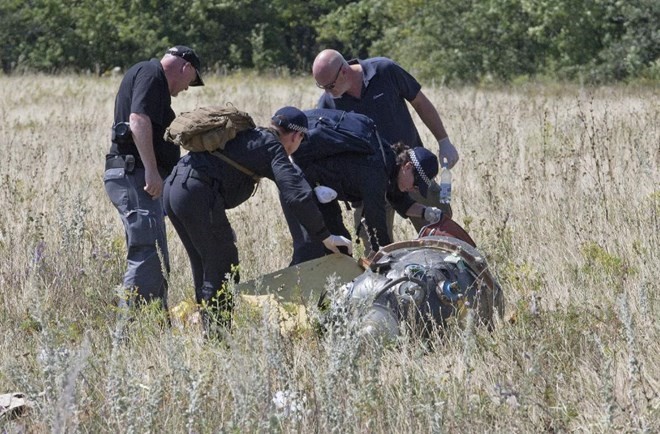 Các chuyên gia Australia tiếp cận một mảnh vỡ của máy bay MH17 hôm 1/8. (Nguồn: AP) 