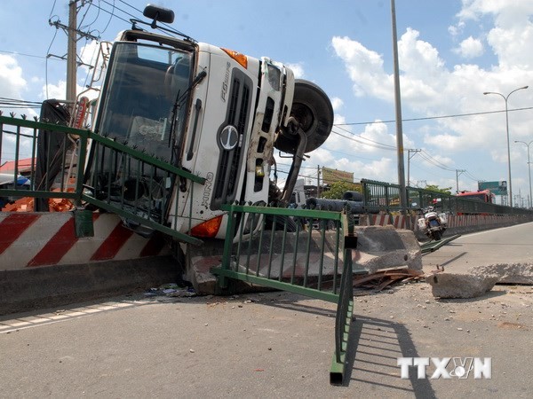 Chiếc xe tải chở gạch bị lật nhào sau khi tránh vụ va chạm xe máy. (Ảnh: Mạnh Linh/TTXVN) 