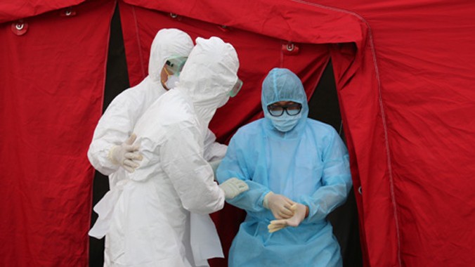 Hành khách bị phát hiện sốt ở sân bay Tân Sơn Nhất được khử trùng, mặc đồ bảo hộ, cách ly đưa đến Bệnh viện Bệnh Nhiệt đới theo dõi phòng dịch Ebola. Ảnh: Nguyên Mi