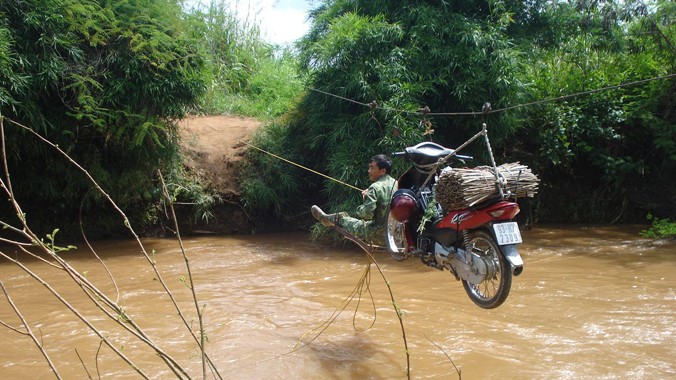 Người và phương tiện đang “bay” qua sông Krông Ana mùa lũ. ảnh: PV