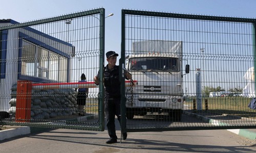 Nhân viên bảo vệ biên giới Nga tại điểm kiếm soát Donetsk mở cửa để đoàn xe viện trợ trở về vùng Rostov. Ảnh: Reuters.