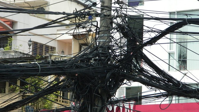Lưới điện hạ thế và cáp viễn thông câu mắc chằng chịt tại giao lộ Hai Bà Trưng - Điện Biên Phủ. Ảnh: LT 
