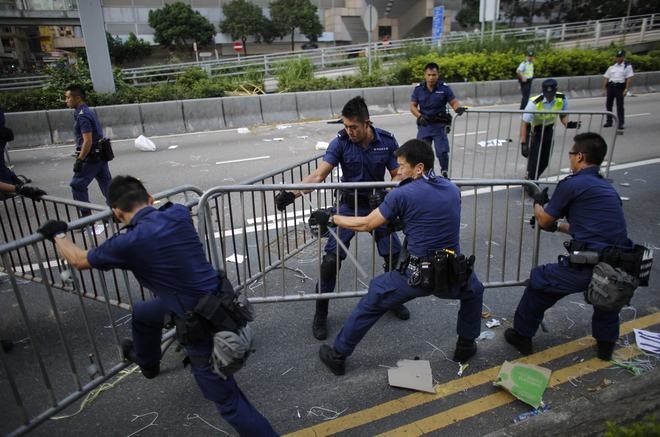 Cảnh sát Hong Kong dỡ bỏ rào chắn kim loại do những người tham gia phong trào “Chiếm trung tâm” dựng lên. 