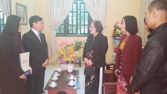 Bà Vân Hiền, giám đốc truyền thông ngân hàng Quốc Dân (NBC)- đầu tiên tay trái và ông Trần Thanh Lâm , phó tổng biên tập Báo Tiền phong trao quà cho cán bộ nhà trường.