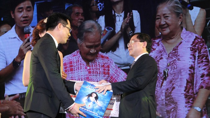 Ông Lê Xuân Sơn- Tổng biên tập báo Tiền Phong tiếp nhận khoản kinh phí giúp đỡ người nghèo Tết Ất Mùi 2015 từ ông Ngô Quốc Cường (trái). 