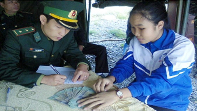 Em Lê Thị Phương Ly đang bàn giao số tiền 18 triệu đồng cho Đồn Biên phòng Roòn.