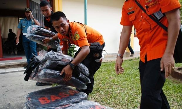 Lực lượng cứu hộ đang chuẩn bị các túi đựng thi thể. Ảnh: The Guardian