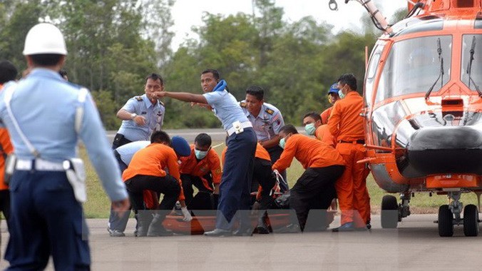 Các nhân viên cứu hộ Indonesia chuyển thi thể một nạn nhân trong vụ tai nạn máy bay QZ8501 ngày 31/12. Ảnh: AFP/TTXVN.