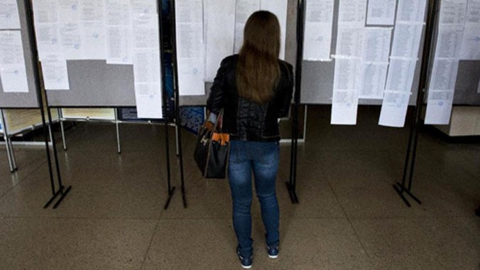 Một phụ nữ xem kết quả thi đầu vào dán trên bảng thông báo của Đại học Donetsk, miền đông Ukraine, hôm 25/9. Ảnh: AFP.